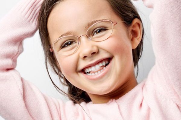 Lachendes Kind mit einer feinen, rosafarbenen Brille